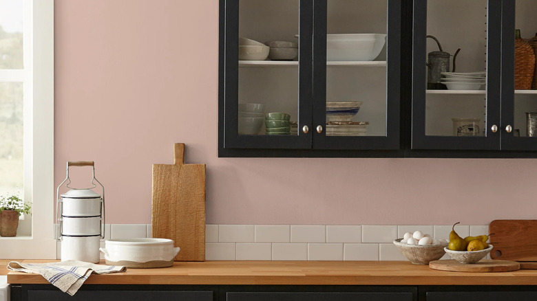 Rosy Pink paint by Magnolia for the kitchen with black cabinets, two layers of a white subway tile backsplash and butcher block countertops.