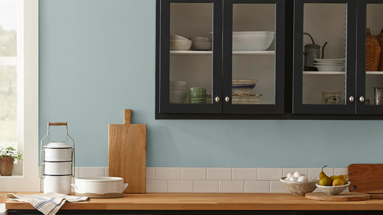 Gray blue wall color called Rainy Days by Magnolia with black cabinets and butcher block counters.