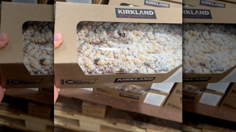 Hand holding raspberry lemon loaf carton.