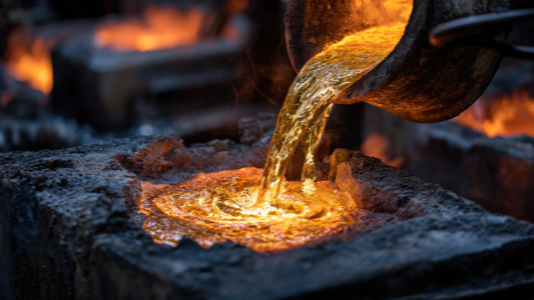 Molten metal being poured from crucible into mold
