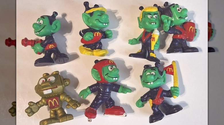 Seven Astroniks figurines against an off-white backdrop