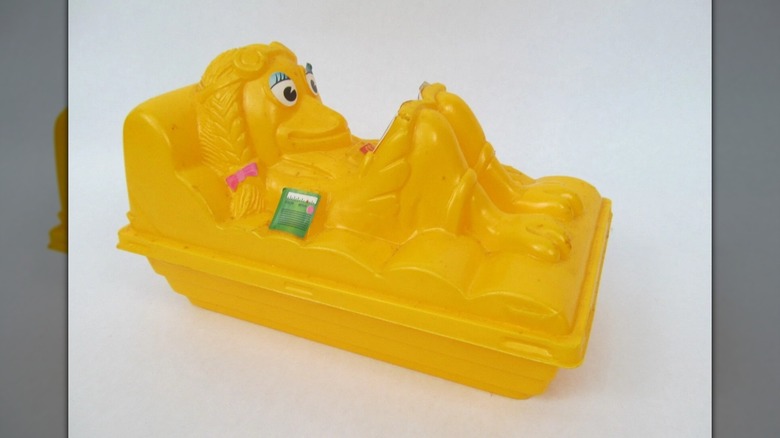 A yellow Birdie floating Happy Meal toy against a white backdrop