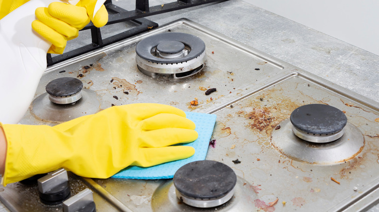 Person cleaning gas stove top