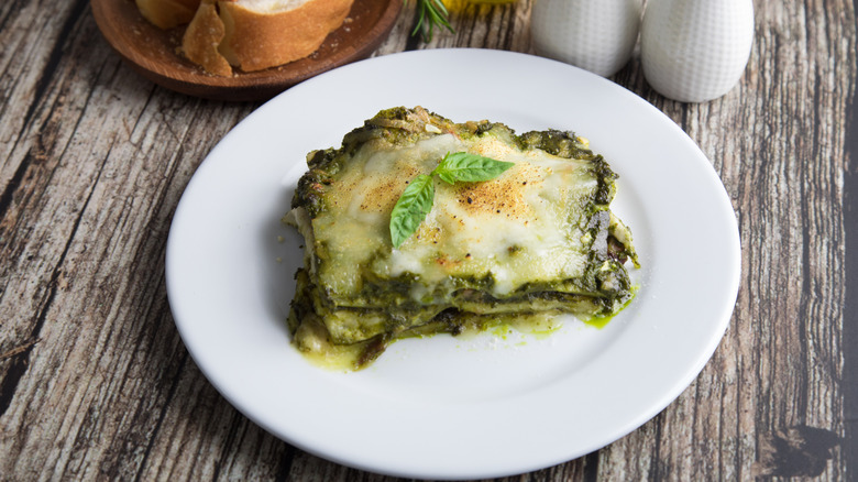 Portion of green lasagna on a white plate