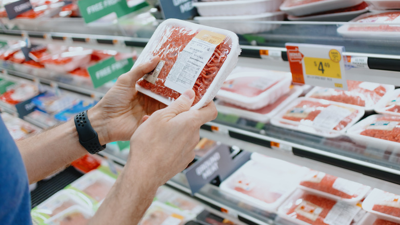 Person inspecting ground beef in store