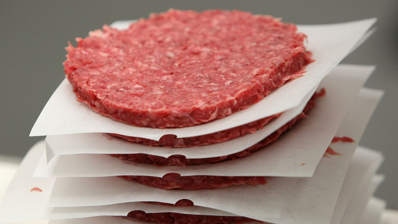 Stack of shaped burgers between paper