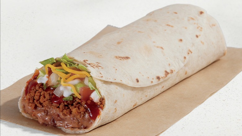 Burrito supreme sitting on brown napkin