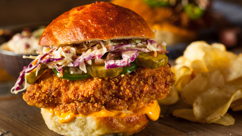 A fast food fried chicken sandwich, served with potato chips