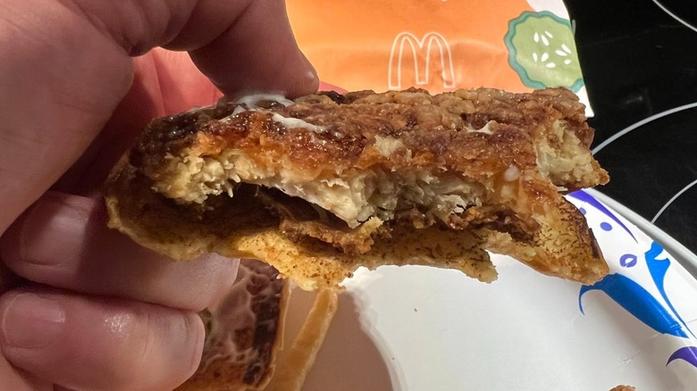 A hand holds a half-eaten McCrispy from McDonald's