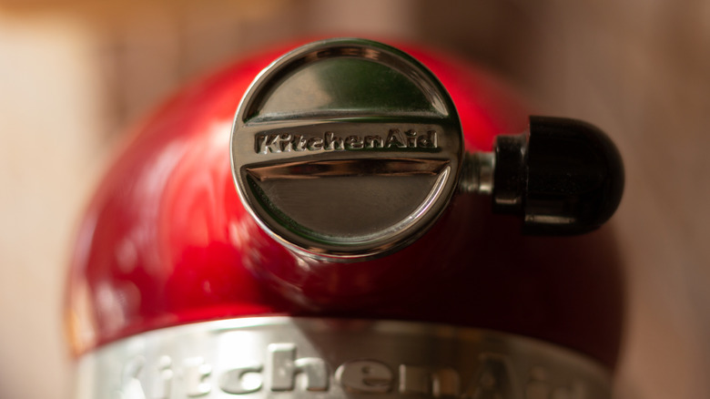 Close up of a KitchenAid stand mixer attachment port against a red machine.