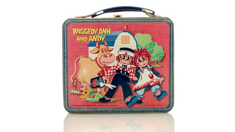 A retro Raggedy Ann lunchbox on a white background