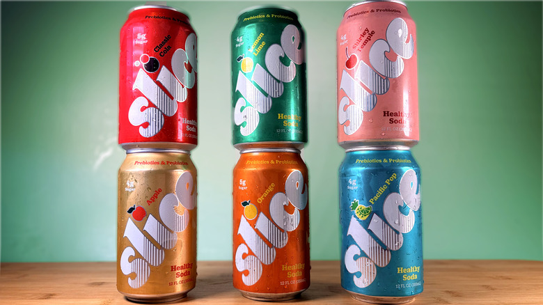 Six cans of Slice prebiotic soda stacked on table