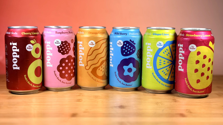Cans of Poppi prebiotic soda lined up on a table