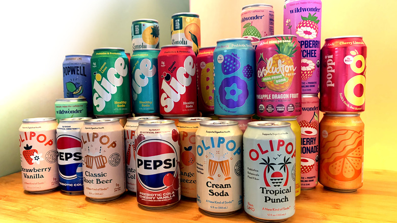 Stacks of a variety of canned prebiotic sodas on a table