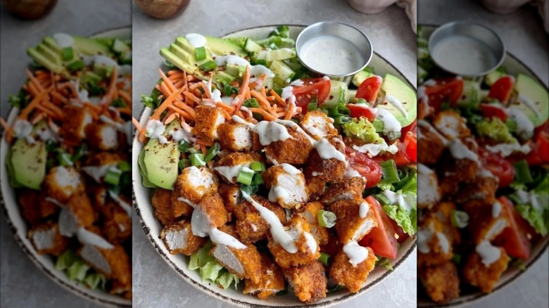 Salad with fried chicken tenders, avocado, carrots, tomatoes, ranch