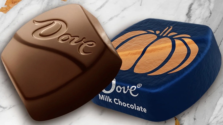 Product image of wrapped and unwrapped Dove milk chocolate pumpkins on a white marble background