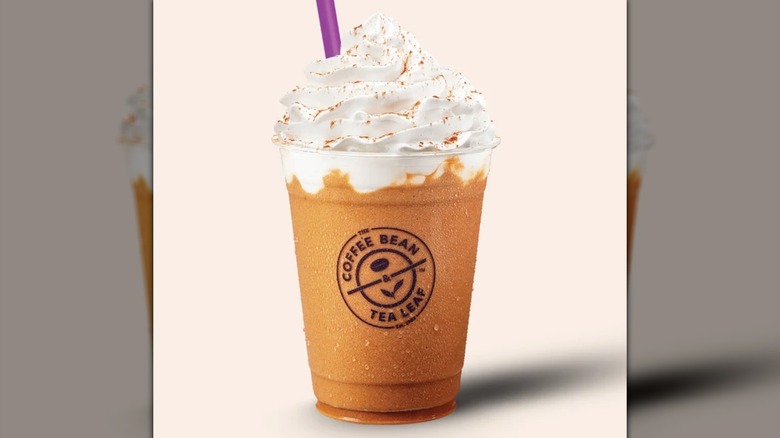 A frozen drink with whipped cream and a straw