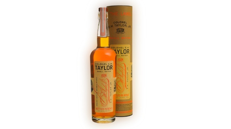 A bottle of E.H. Taylor, Jr. Small Batch bourbon next to its packaging tube