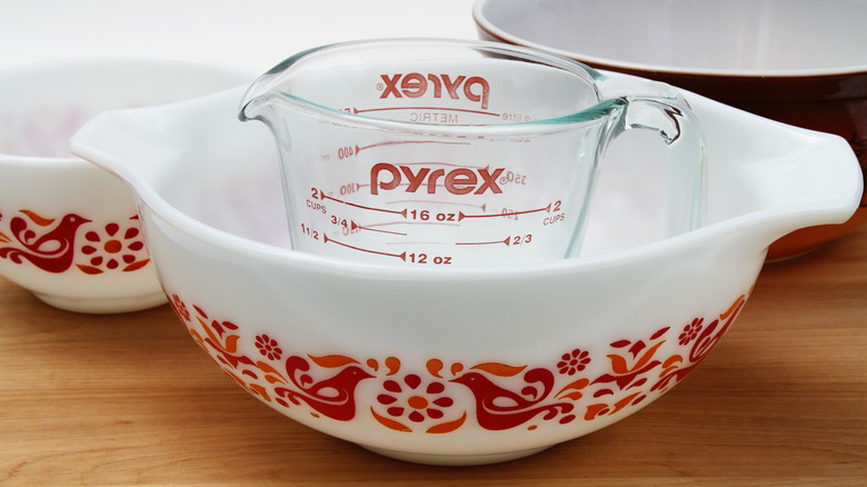 Red-patterned Pyrex bowl with Pyrex measuring cup sitting inside