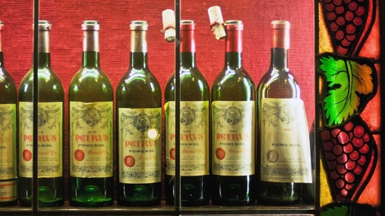 bottles of petrus in window with stained glass grape motif