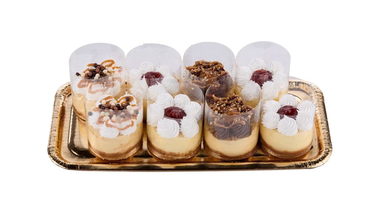 Eight mini cheesecakes on a gold tray