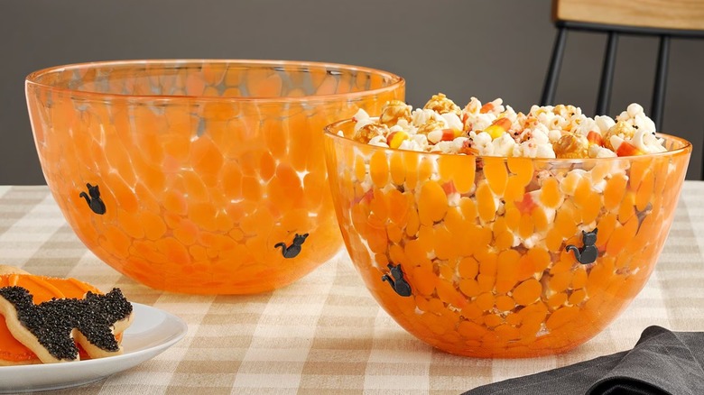 Orange glass bowls, one with popcorn
