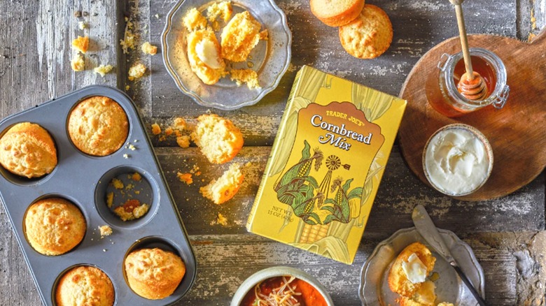 Box of Trader Joe's Cornbread Mix surrounded by made muffins in and out of tins