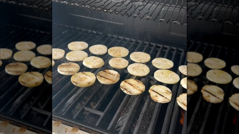 Several radish slices grilling directly on the grate, with grill marks visible on some