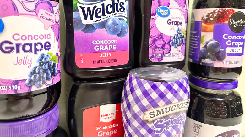 Extreme close up of several grape jelly bottles from different brands