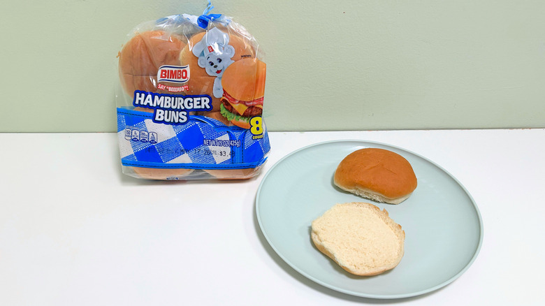 A bag of Bimbo Hamburger Buns next to a plate of hamburger buns