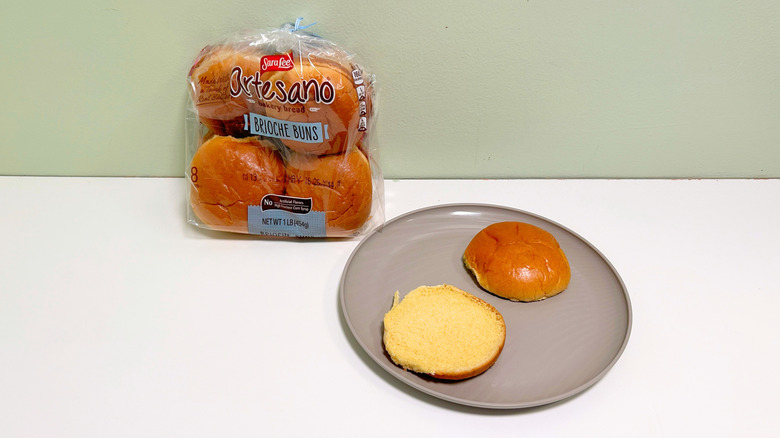 A bag of Sara Lee Artesano Brioche Buns next to a plate of hamburger buns