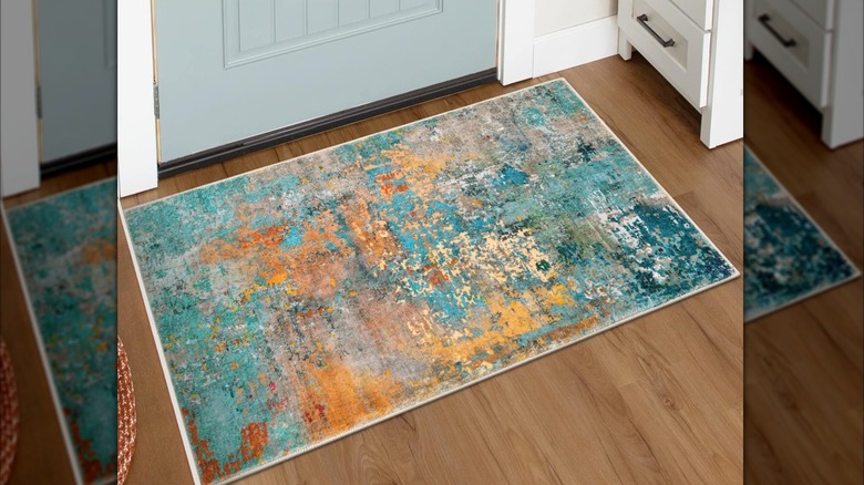 turquoise and orange toned rug by blue door
