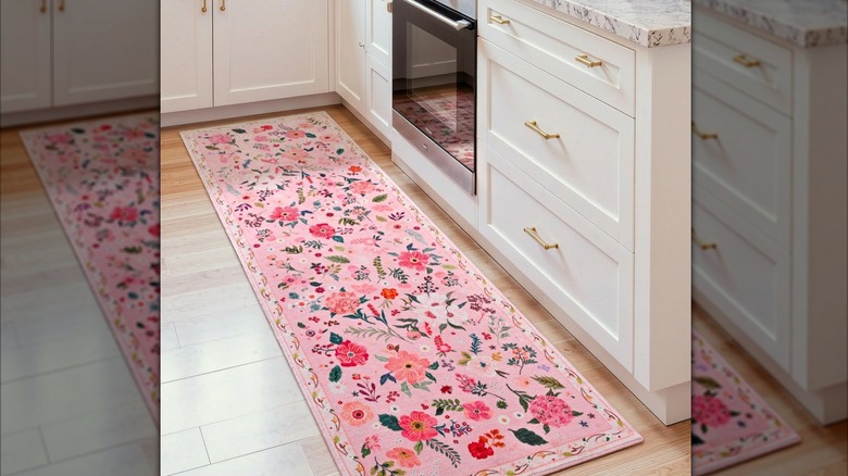 Pink runner rug on floor by white cabinets