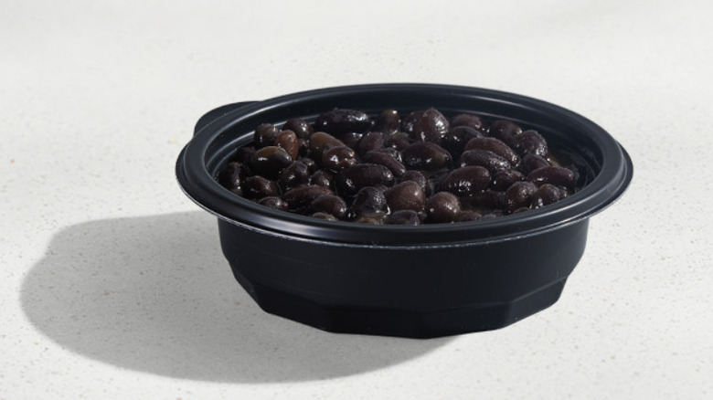 Black beans in a cup on a white table