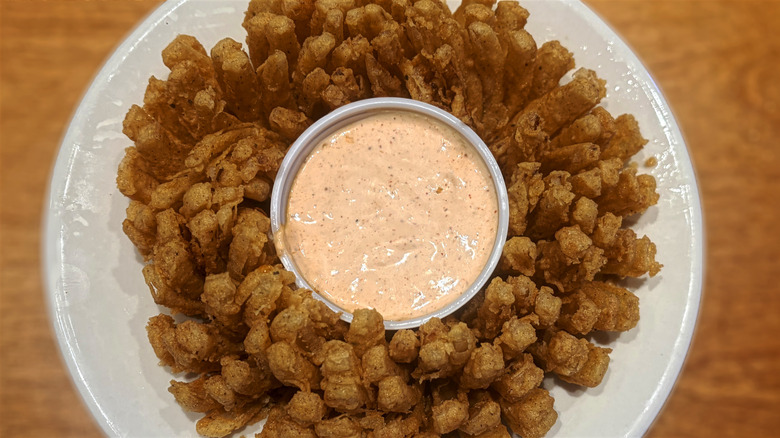 cactus blossom fried onion dish with container of cajun horseradish sauce in center