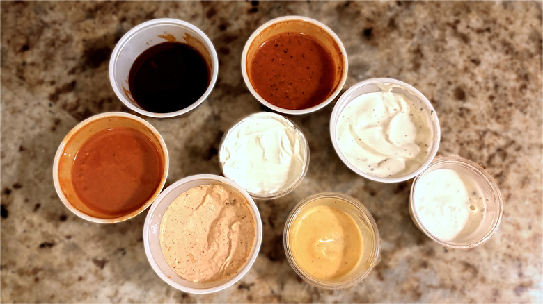 top down view of plastic containers of eight texas roadhouse dipping sauces