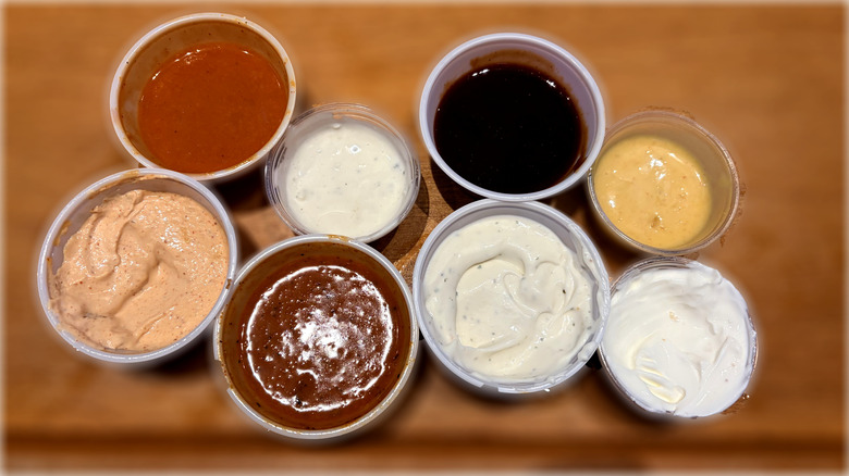 top down view of plastic containers of eight texas roadhouse dipping sauces