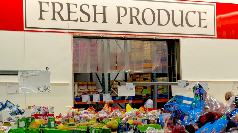 A display for the Costco Fresh Produce section, showing a large table of fruits under a sign