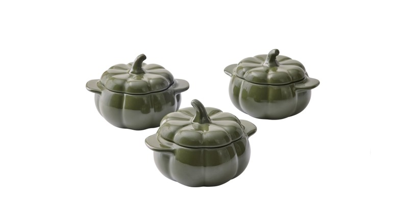 Three pumpkin-shaped cocottes against a white background.