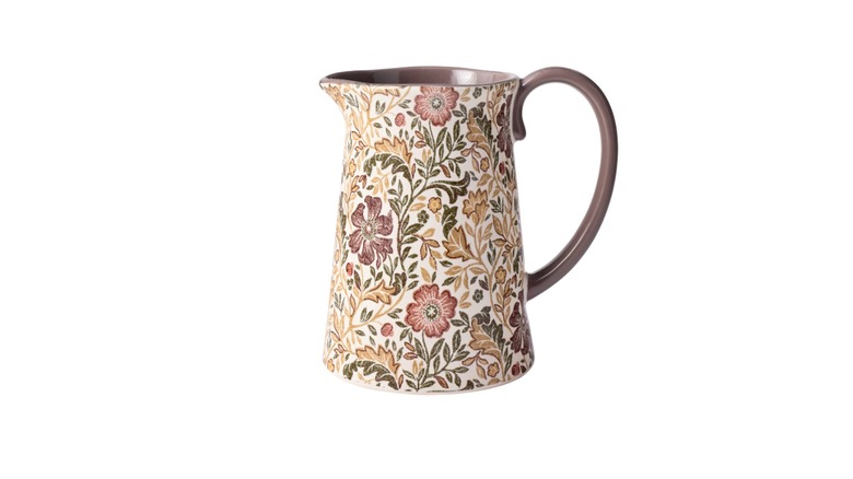 Stoneware pitcher with floral pattern against a white background