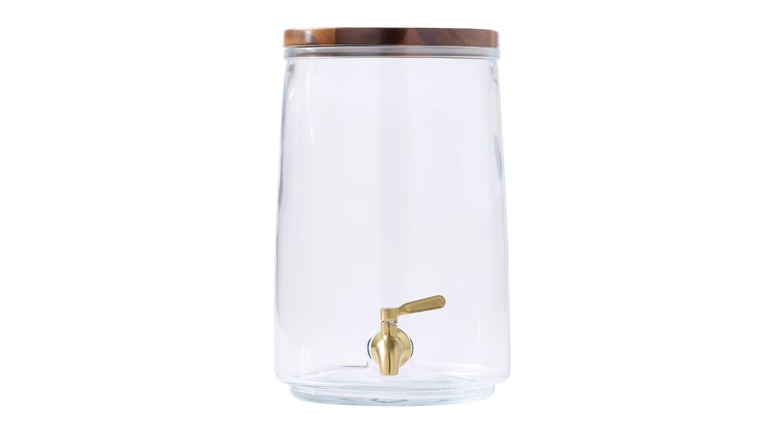 Large clear drink container with spout and wooden lid against a white background