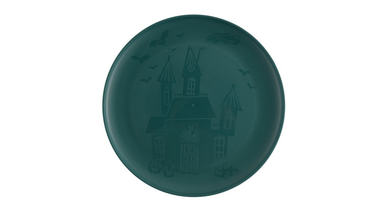 Dark blue-green plate with etching of haunted house against a white background