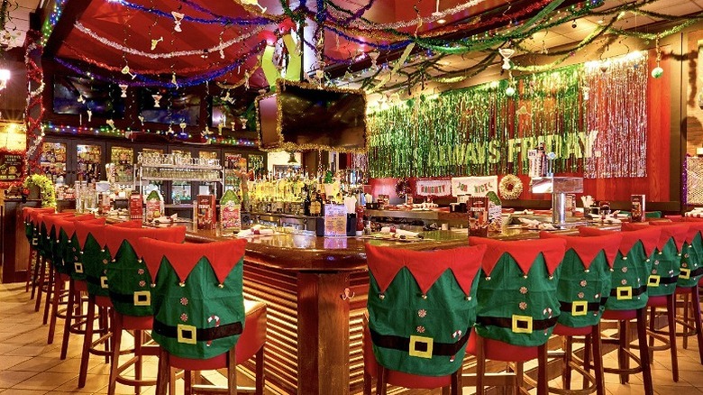 TGI Fridays bar area with chairs decorated with elf costumes and Christmas decorations