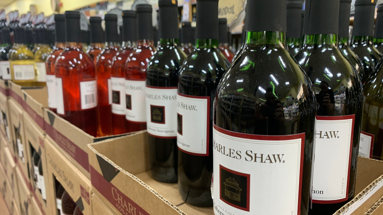 Bottles of red and pink Charles Shaw wines in cardboard trays.