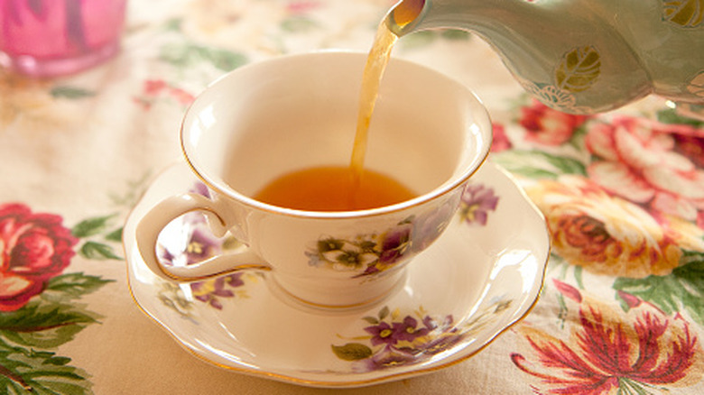 Tea getting poured into a cup