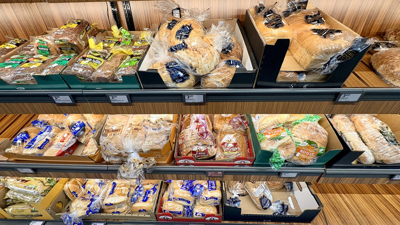 Several Aldi breads stocked in boxes on the grocery store shelf