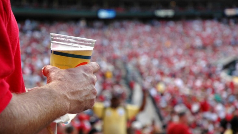Hand holding beer at baseball stadium