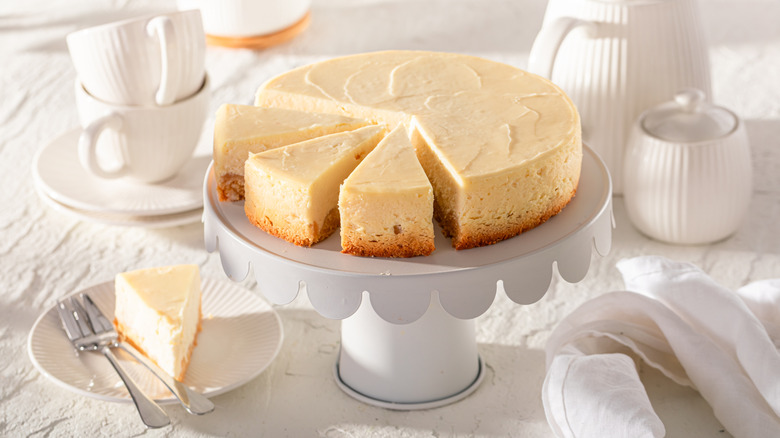 Sliced cheesecake on white serving board