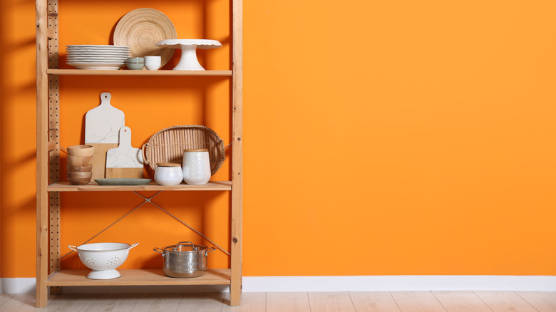 Wooden shelves against a bright orange wall