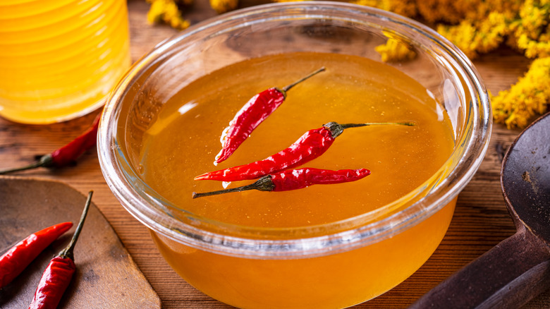 A bowl of hot honey with red chile peppers